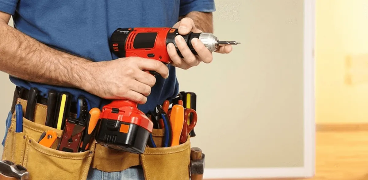 Handyman holding a power drill for home repairs and installations in Arlington, TX